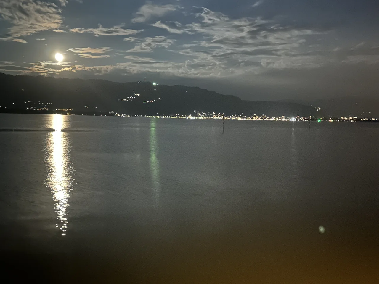 Bregenz waterfront and the Pfänder silhouette under a full moon, viewed from Lindau