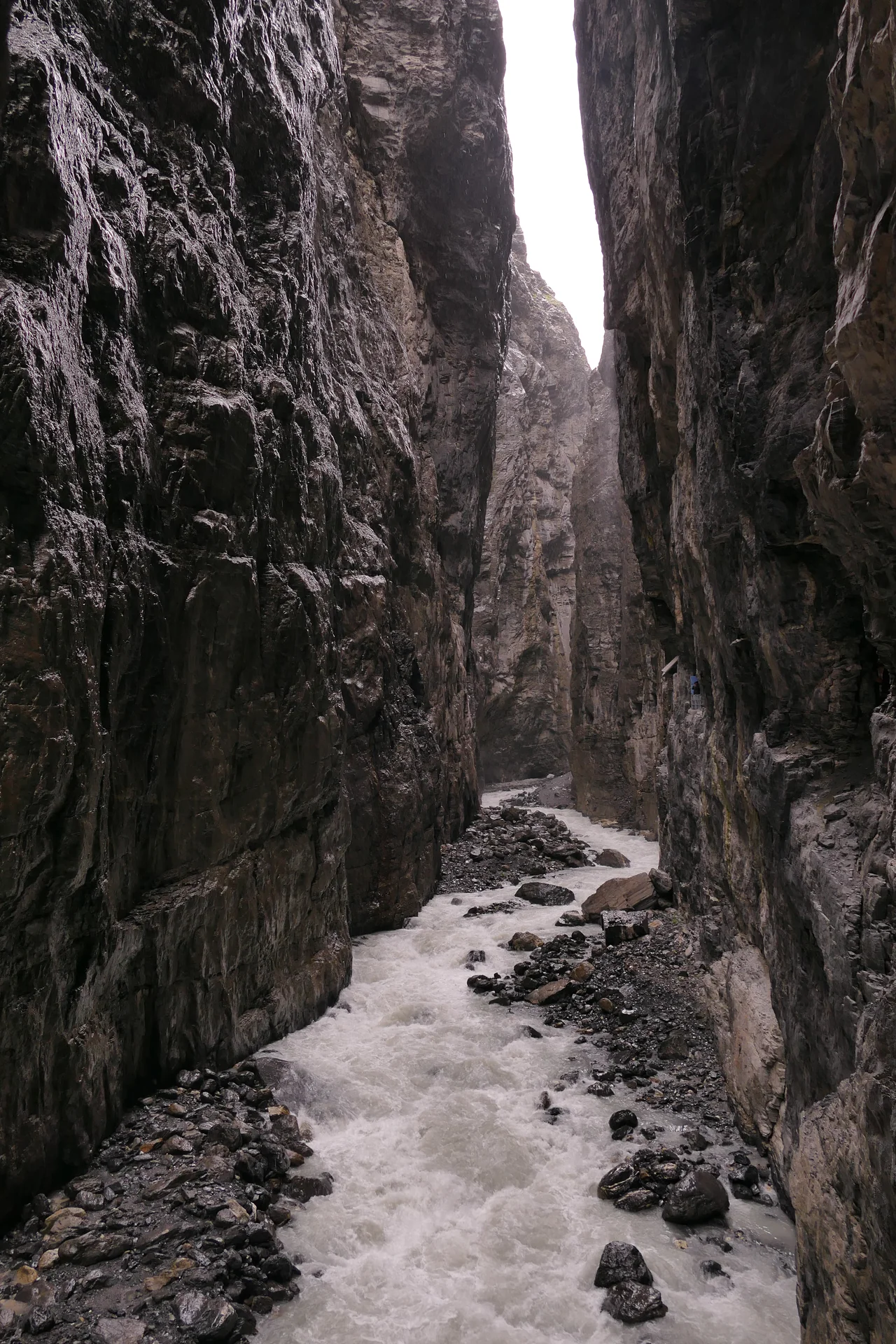Rock walls and flowing water inside Grindelwald Glacier Canyon