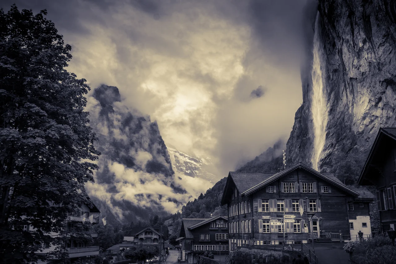 Staubbach Falls above the timber houses of Lauterbrunnen village